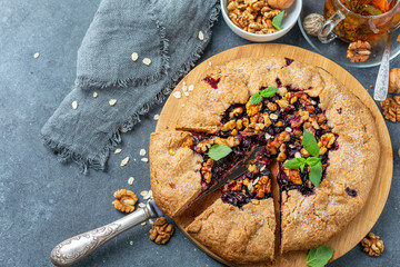 Cut galette pie with oats, currants and walnuts.