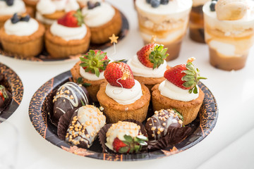 candy buffet.Fruit tart with cream, cakes and sweetness on white background. Delicious dessert and candy bar.sweet buffet with cupcakes. Sweet holiday buffet with cupcakes