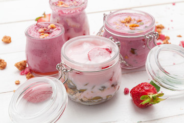 Strawberry with yogurt on white rustic wooden background. Cream dessert