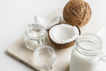 Organic healthy coconut butter and fresh coconut pieces on wooden board