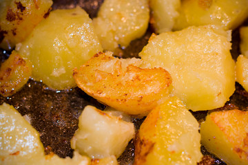 Fried potatoes in a pan with a golden brown mineral coating in vegetable oil. close-up photo.