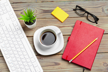 Top view of wooden desktop with glasses and stationery items close up. Mock up