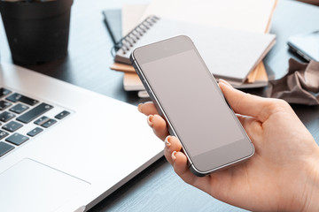 Close up of female hands using smartphone at office table