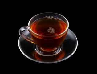 Glass cup of tea isolated on black