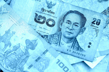 Fototapeta premium Various banknotes thai baht close up. Money background blue color toned