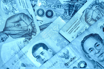 Various banknotes thai baht close up. Money background blue color toned