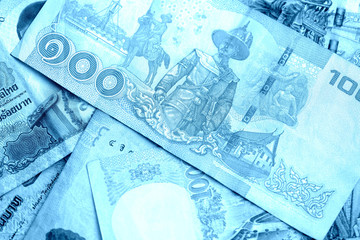Various banknotes thai baht close up. Money background blue color toned