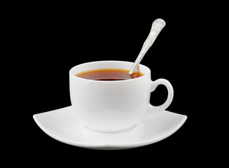 Cup of fresh tea with spoon and saucer isolated on black