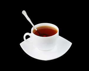 Cup of fresh tea with spoon and saucer isolated on black