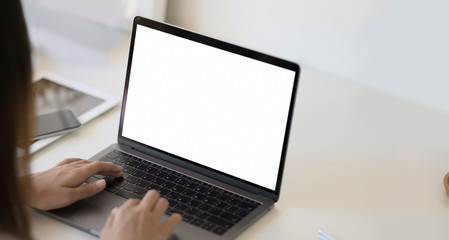 Woman using laptop on white workspace desk