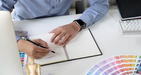 Graphic designer working with drawing tablet and colour swatches