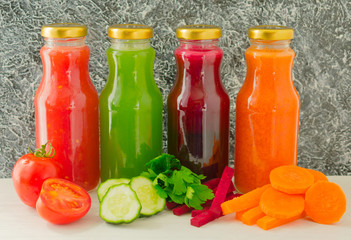 Four vegetable juices in glass bottles. A large plan. The concept of healthy eating.	