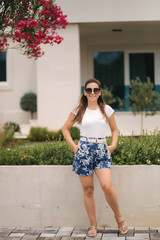 Stylish beautiful woman walking near the pier by the sea