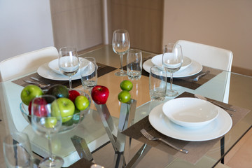 Dining room with a table for dinner with fruit.