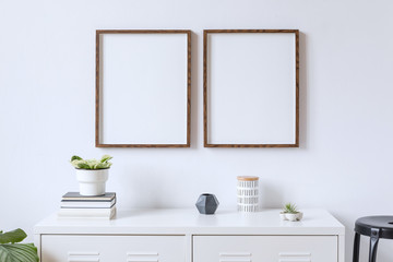 Minimalistic home decor of interior with two brown wooden mock up photo frames on the white shelf...