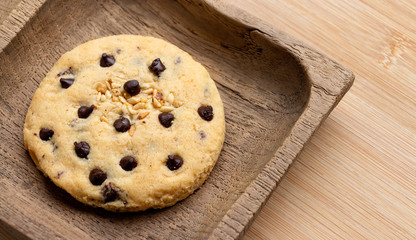 Chocolate chip cookie with wooden tray on the wood table. Delicious homemade baked cookie.