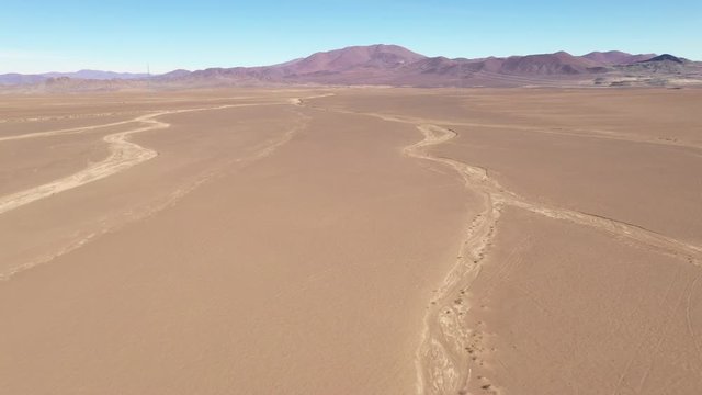 Exploring Atacama Desert vast dry extensions in the driest area of this amazing desert with an all terrain vehicle. An awe road trip adventure crossing the infinite sand extensions from an aerial view