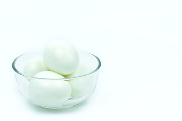 Fototapeta na wymiar Isolated of four hard boiled chicken eggs in clear glass bowl on white background with copy space on the right.