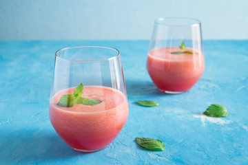 Watermelon melon strawberry smoothie. Summer cocktail with ice and mint on a blue turquoise background with copy space