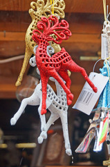Christmas tree decorations made of glass, wood and fabric of different shapes and colors on the counter at the festive fair