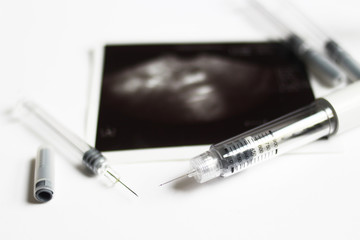 Assisted reproductive technology injection pen and small syringes with ovarian ultrasound in the middle. IVF and IUI Treatment Drugs. Medication  for infertility treatment