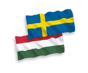 National vector fabric wave flags of Sweden and Hungary isolated on white background. 1 to 2 proportion.