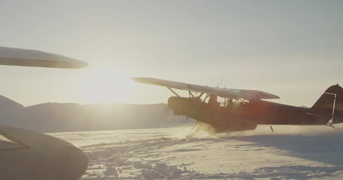 Airplane in deep snow taking off.