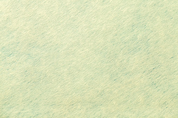 Light green background of felt fabric. Texture of woolen textile