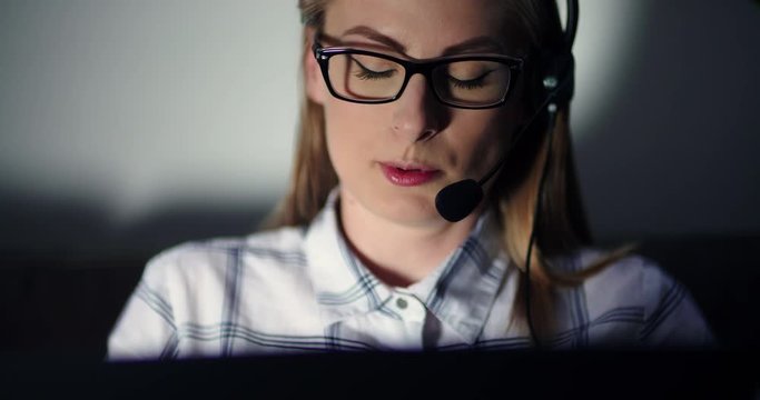 Businesswoman Using Headset And Laptop In Office