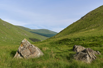 Fototapeta na wymiar Two Boulders, possibly Glacial Erratics lie at the Head of the Valley in Glen Doll, part of the Cairngorm National Park in The Highlands of Scotland.