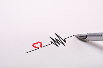 Heart rhythm hand drawing, electrocardiogram, heart beat pulse line concept on white paper