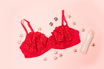 Red bra with lace. star decor, lubricant on a white background. The apartment was lying. Fashion...