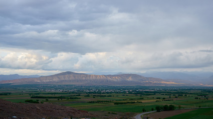 View from the top of the mountain at sunset, clouds in the sky.