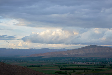 View from the top of the mountain at sunset, clouds in the sky.