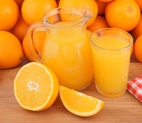 Obraz na płótnie Canvas Orange juice with many orange fruits as background