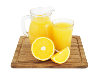Orange juice in glass and pitcher with orange fruit slices on wooden board isolated on white