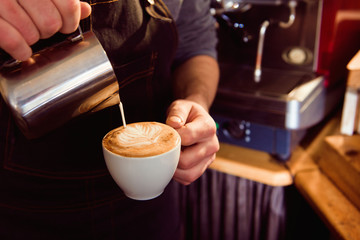 Fototapeta na wymiar Coffee Latte Barista making pattern in a cup of coffee shop.