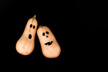 Funny scary face Halloween pumpkins on black background. Flat lay, top view background.