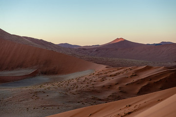 Early morning sunlight illuminating the red sand of Namibias sussusvlei