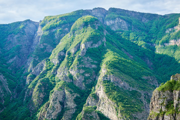 View of mountain snowy ridges on a bright sunny day with clouds in the sky.