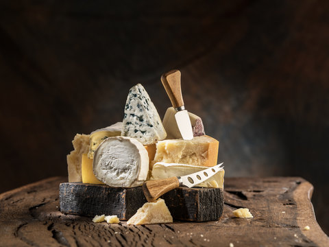 Assortment of different cheese types on wooden background. Cheese background.