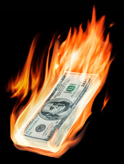 Burning one-hundred dollar bills in flames on black background.