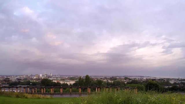 Cityscape timelapse fast moving cloud above Everton, Liverpool, British city harbour skyline from high viewpoint.
