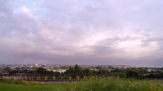 Cityscape timelapse fast moving cloud above Everton, Liverpool, British city harbour skyline from high viewpoint.