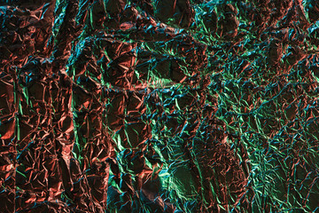 Fototapeta premium top view of crumpled foil with colorful lighting reflection