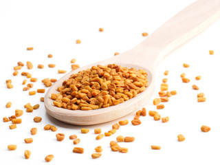 Diagonal wooden (Trigonella) spoon with fenugreek on a white background