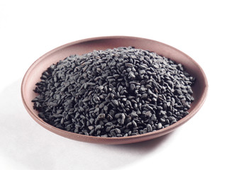 Black sesame (Sesamum indicum) in a clay plate on a white background