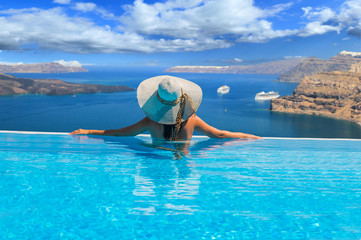 Woman enjoying relaxation in pool and looking at the view
