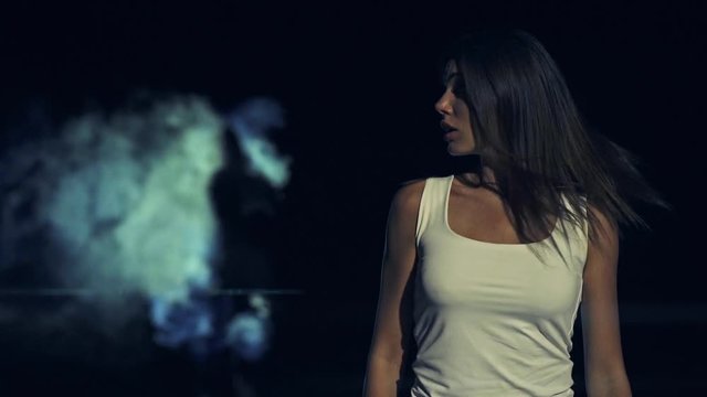 The woman walking in the dark street on the man background
