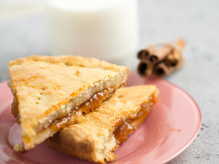 homemade cake with jam and a Cup of milk on the table